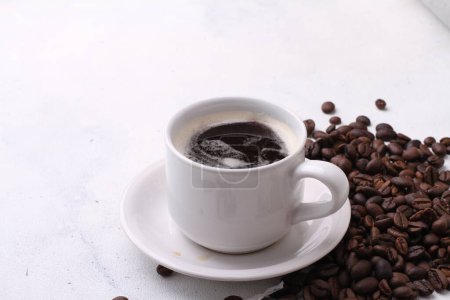 Téléchargez les photos : Une tasse de café noir sur une table blanche - en image libre de droit