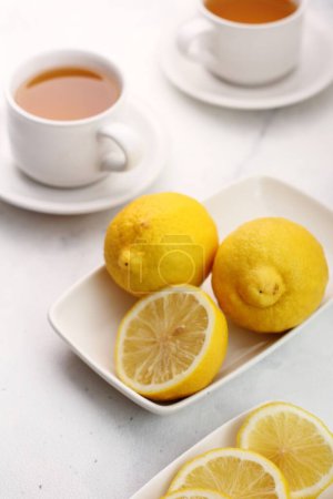 Photo for White tea with lemon and cinnamon on the table. - Royalty Free Image