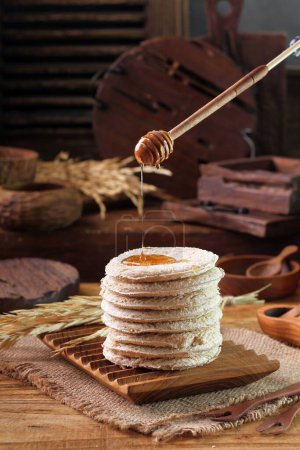 Foto de Panqueques caseros con miel y chocolate sobre un fondo de madera - Imagen libre de derechos