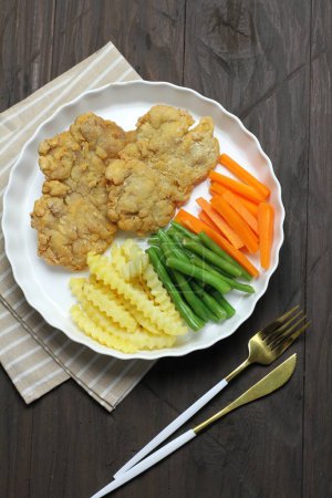 Foto de Pechuga de pollo con espárragos y papas, zanahorias, brócoli, zanahoria, col verde y salsa blanca en un - Imagen libre de derechos