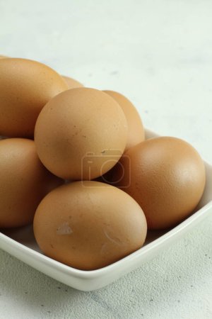 Photo for Fresh raw chicken eggs in a bowl on a white background - Royalty Free Image