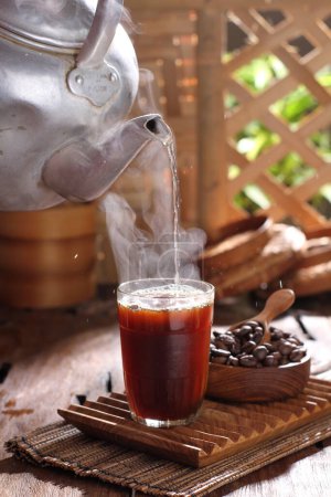 Foto de Café caliente con canela y hielo sobre fondo de madera - Imagen libre de derechos