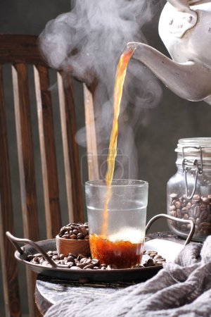 Foto de Taza de café con chocolate caliente y palitos de canela sobre un fondo de madera - Imagen libre de derechos