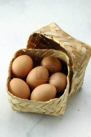 Foto de Huevos en una canasta sobre un fondo blanco - Imagen libre de derechos