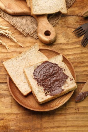 Foto de Pan con mantequilla y chocolate sobre fondo de madera - Imagen libre de derechos
