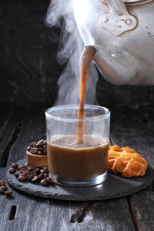 Téléchargez les photos : Tasse de café avec des bâtons de chocolat et de cannelle sur un fond en bois - en image libre de droit