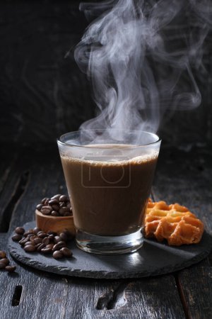 Téléchargez les photos : Tasse de café avec chocolat et cannelle sur un fond sombre - en image libre de droit
