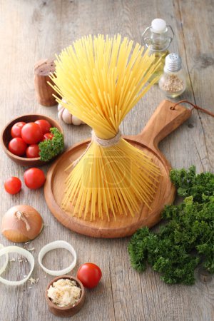 Photo for Pasta with tomatoes and basil on wooden background - Royalty Free Image