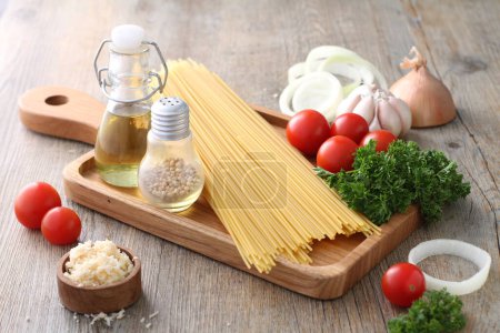 Photo for Ingredients for cooking pasta, tomatoes, garlic, pepper and basil on wooden background - Royalty Free Image