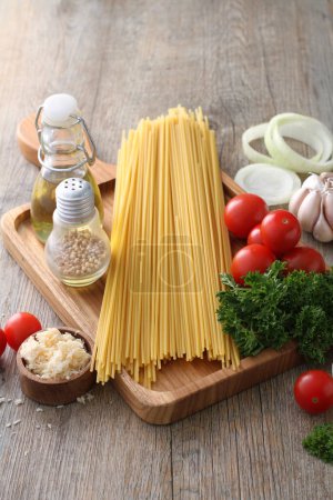 Photo for Pasta with tomatoes, garlic and basil on wooden background - Royalty Free Image