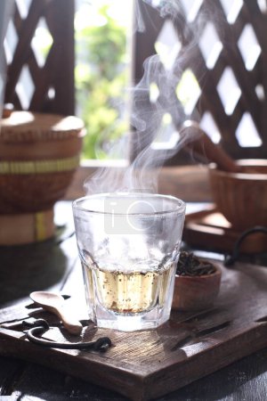 Foto de Té caliente con limón y hielo sobre mesa de madera - Imagen libre de derechos