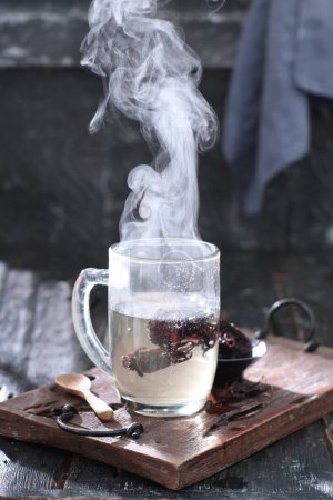 Photo for Cup of tea with smoke and red ribbon - Royalty Free Image