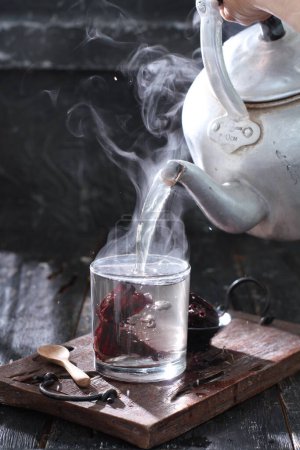 Téléchargez les photos : Tasse à thé avec fumée rouge sur un fond en bois - en image libre de droit