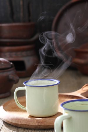 Foto de Té verde y una taza de bebida caliente en una mesa de madera - Imagen libre de derechos