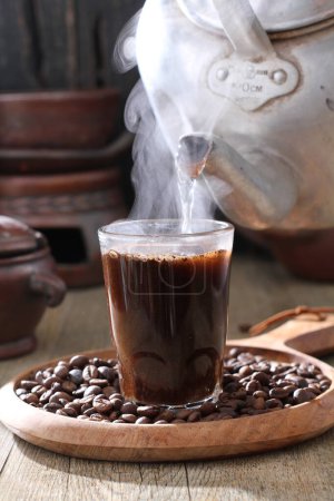 Foto de Grano de café en una taza con café caliente - Imagen libre de derechos