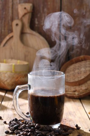 Foto de Taza de café y granos de café caliente en la mesa de madera - Imagen libre de derechos