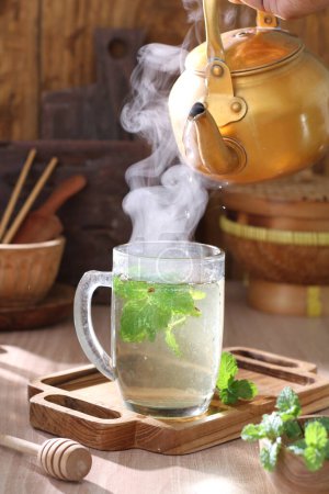 Téléchargez les photos : Thé vert chaud avec des feuilles de citron et de menthe - en image libre de droit