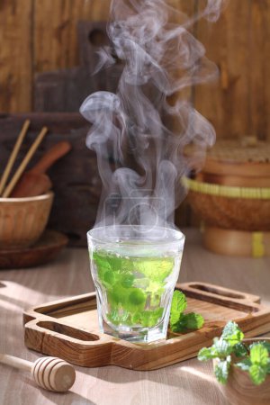 Photo for Hot green tea in glass cup on wooden background - Royalty Free Image
