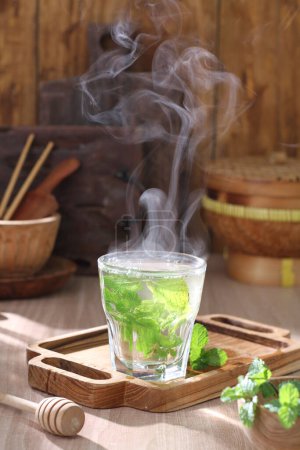 Foto de Hojas de té verde en una taza sobre una mesa - Imagen libre de derechos