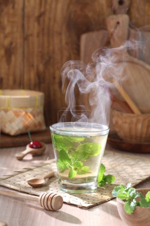 Téléchargez les photos : Tasse de thé chaud avec des feuilles de citron et de menthe - en image libre de droit