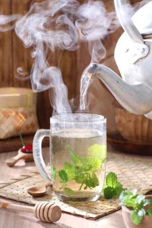 Téléchargez les photos : Tasse de thé et théière sur fond en bois - en image libre de droit