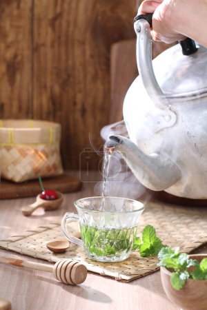 Téléchargez les photos : Thé vert dans une tasse et une tasse avec une théière et une théière - en image libre de droit