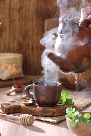 Photo for Hot tea in a cup on a wooden table - Royalty Free Image