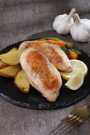 Téléchargez les photos : Poitrine de poulet grillée avec pommes de terre et citron - en image libre de droit
