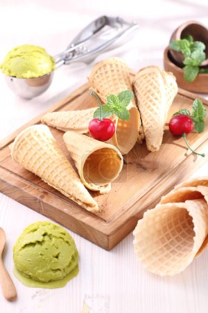 Foto de Sabroso cono de gofre con menta fresca y helado en la mesa blanca - Imagen libre de derechos