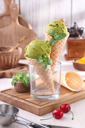 Photo for Ice cream with waffle cone and mint leaves on wooden table - Royalty Free Image
