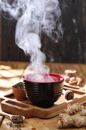 Photo for Cup of aromatic coffee with hot smoke on wooden table - Royalty Free Image