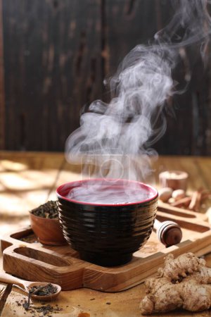 Téléchargez les photos : Une tasse de thé sur un fond en bois - en image libre de droit