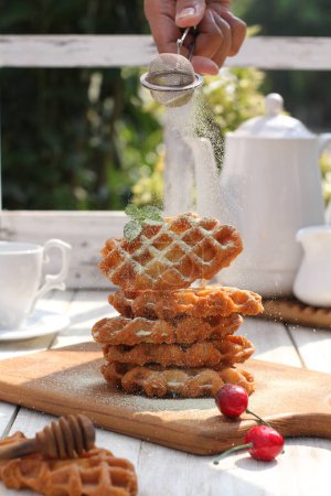 Téléchargez les photos : Un plan vertical d'une délicieuse gaufre avec une tasse de café et des biscuits sur une table en bois - en image libre de droit