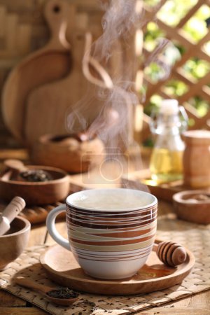 Téléchargez les photos : Tasse de thé avec théière sur table en bois - en image libre de droit