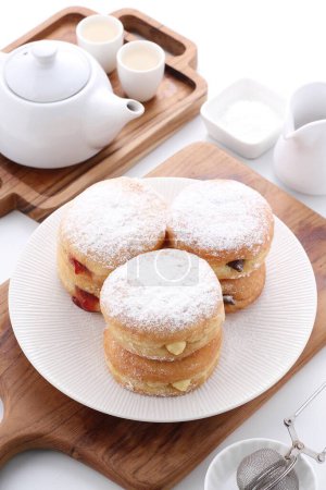Photo for Board with tasty doughnuts and tea on table - Royalty Free Image