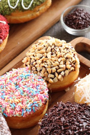Photo for Donuts and chocolate sprinkles on a wooden background - Royalty Free Image