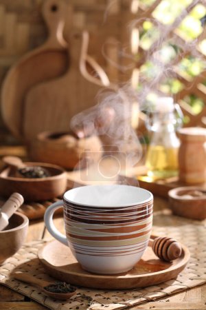 Téléchargez les photos : Tasse de thé chaud avec vapeur sur la table - en image libre de droit