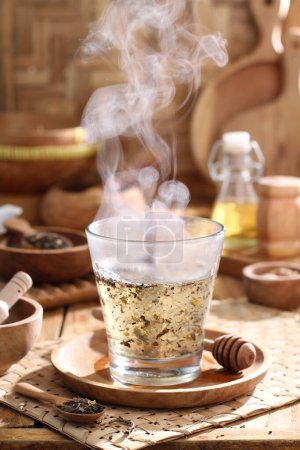 Téléchargez les photos : Tasse de boisson aromatique chaude et des épices sur plateau en bois plateau sur table dans la cuisine - en image libre de droit