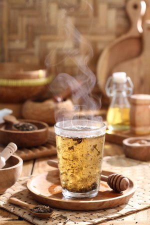 Foto de Vaso de té con limón y canela sobre mesa de madera - Imagen libre de derechos
