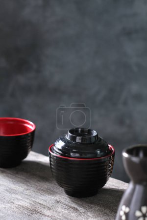 Photo for Black and red ceramic cups and teapot on a dark background - Royalty Free Image