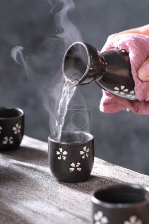 Téléchargez les photos : Gros plan d'une main tenant une tasse de thé chaud - en image libre de droit