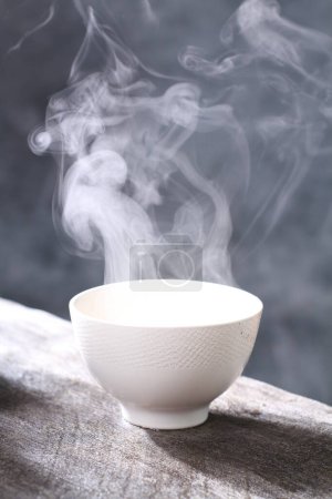 Téléchargez les photos : Tasse de thé avec vapeur sur la table - en image libre de droit