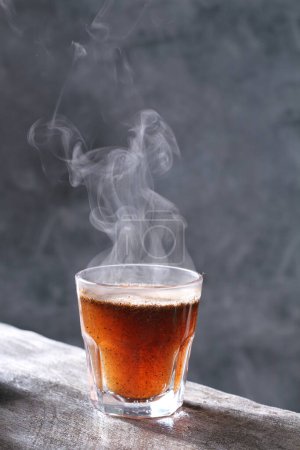 Foto de Taza de té caliente con vapor en la mesa de madera - Imagen libre de derechos