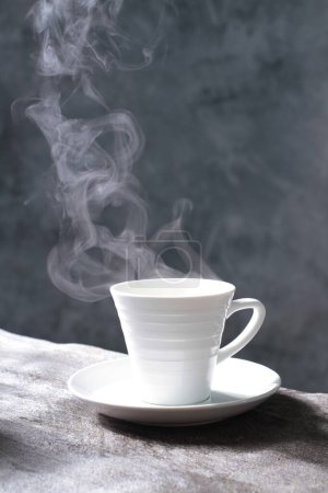 Téléchargez les photos : Tasse de café et de fumée sur fond sombre - en image libre de droit