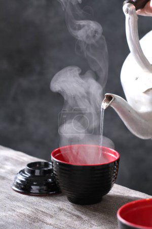 Foto de Taza de té con tetera sobre mesa negra - Imagen libre de derechos
