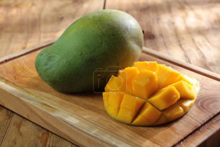 Téléchargez les photos : Fruits de mangue frais sur assiette en bois - en image libre de droit