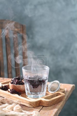 Foto de Taza de té negro con palitos de canela y anís en la mesa de madera - Imagen libre de derechos