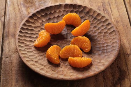 Photo for Sweet dried apricots in a wooden bowl on a wooden table - Royalty Free Image