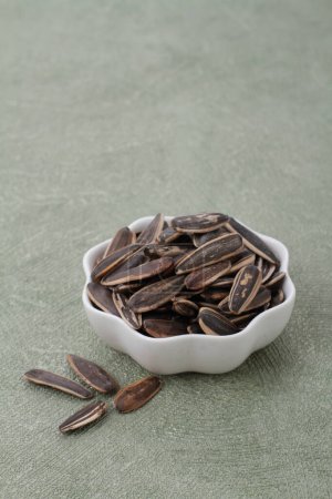 Foto de Tazón con sabrosas semillas de calabaza en la mesa gris, primer plano - Imagen libre de derechos