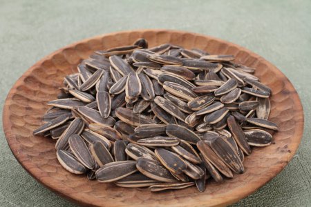 Photo for Sunflower seeds in wooden bowl on wooden table - Royalty Free Image
